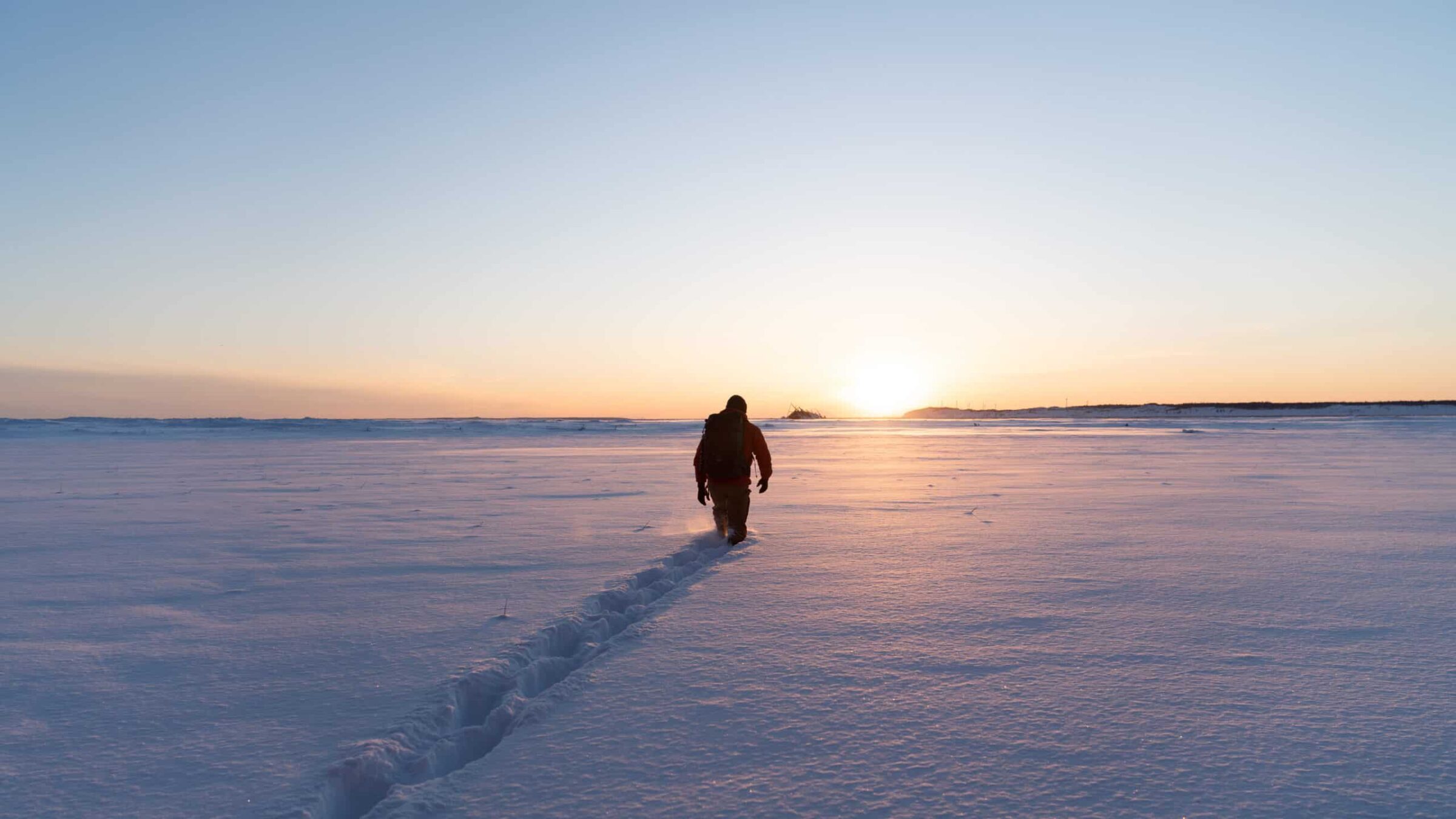 Using digital field camera Phase One XT a photographer captures a man walking in the snow.